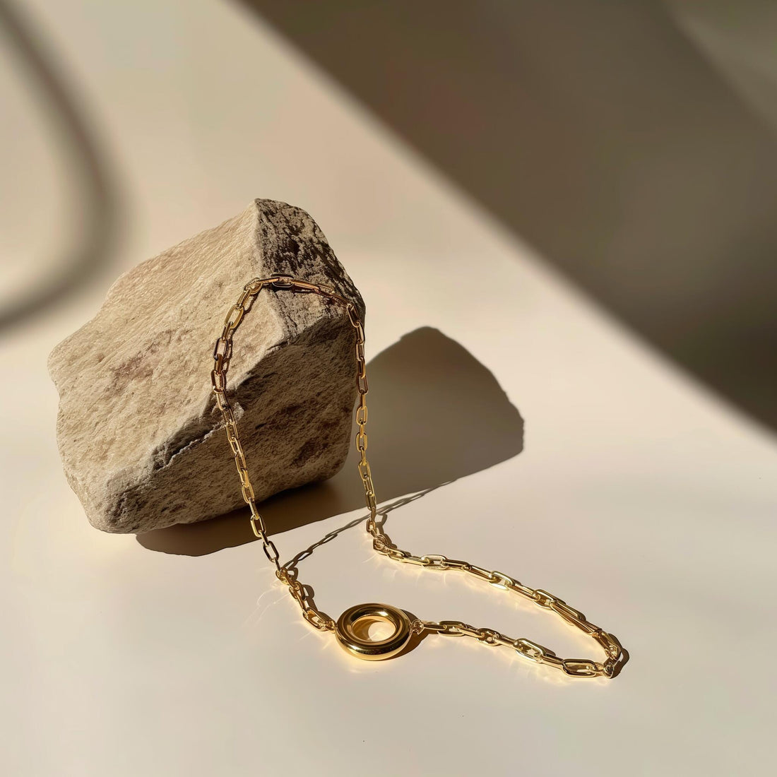 Gold charm bracelet on stone background – elegant anniversary jewelry gift idea
